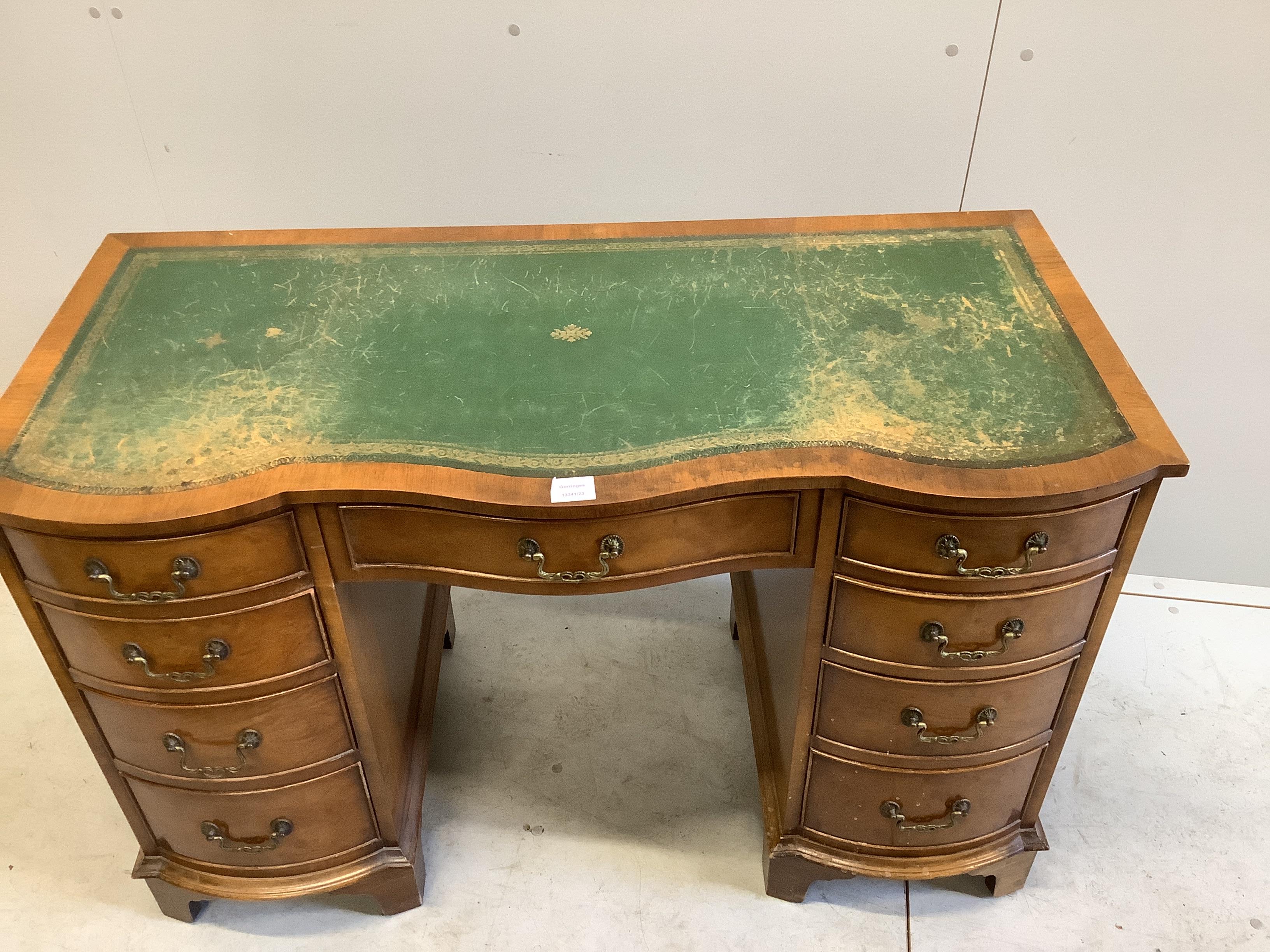 A reproduction walnut serpentine kneehole desk, width 115cm, depth 53cm, height 75cm